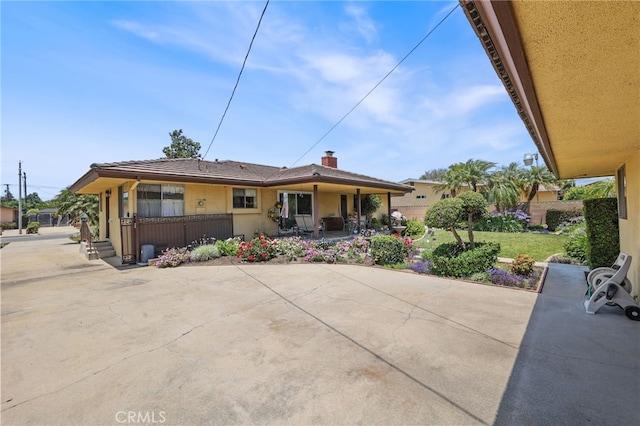 12429 Baker Ave, Chino, CA 91710 - rear view of property featuring a patio, stucco siding, a chimney, and driveway