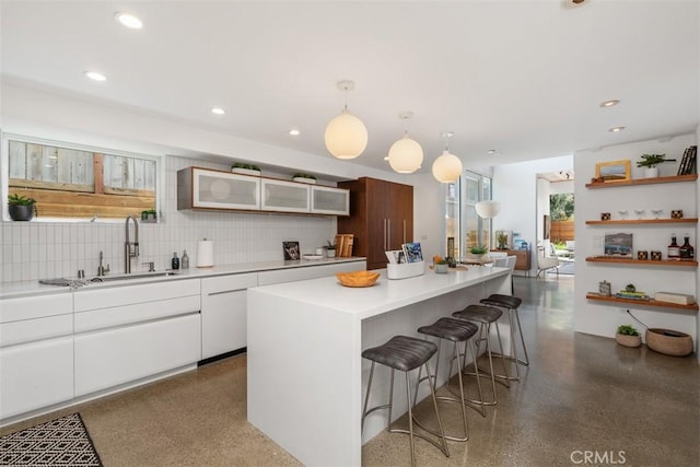 417 Sunset Ave Unit 1.2, Venice, CA 90291 - kitchen featuring a breakfast bar, white cabinets, decorative backsplash, glass insert cabinets, and recessed lighting