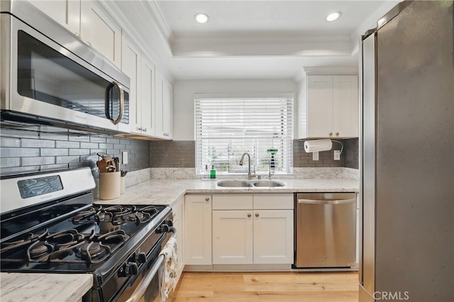 14861 Mulberry Dr Unit 1310, Whittier, CA 90604 - kitchen with stainless steel appliances, crown molding, light wood-style floors, white cabinets, and a tray ceiling