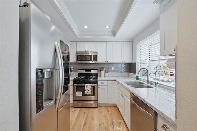 14861 Mulberry Dr Unit 1310, Whittier, CA 90604 - kitchen with appliances with stainless steel finishes, light wood finished floors, decorative backsplash, white cabinetry, and light stone counters
