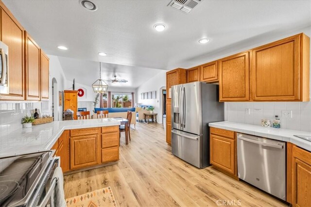 3715 Surrey, Yucca Valley, CA 92284 - kitchen featuring appliances with stainless steel finishes, tile countertops, light wood-style flooring, decorative backsplash, and recessed lighting