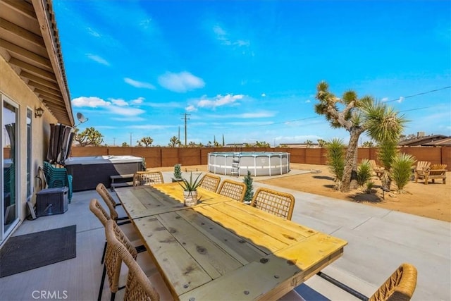3715 Surrey, Yucca Valley, CA 92284 - fenced backyard featuring a hot tub, outdoor dining area, and a patio