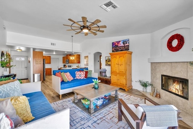 3715 Surrey, Yucca Valley, CA 92284 - living area featuring a ceiling fan, arched walkways, a fireplace, and light wood-style floors