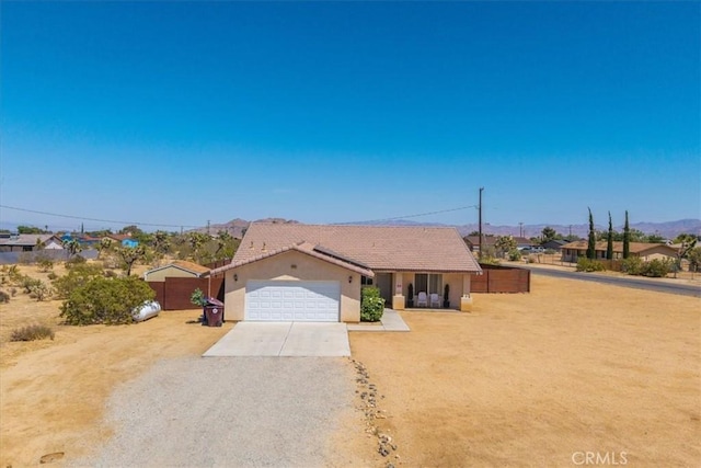 3715 Surrey, Yucca Valley, CA 92284 - ranch-style house featuring concrete driveway, stucco siding, a tile roof, and a garage