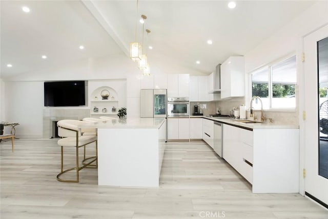 23500 Lloyd Houghton Pl, Newhall, CA 91321 - kitchen featuring appliances with stainless steel finishes, modern cabinets, vaulted ceiling, white cabinetry, and a center island