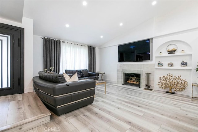 23500 Lloyd Houghton Pl, Newhall, CA 91321 - living room with a fireplace, wood finished floors, lofted ceiling, recessed lighting, and built in shelves