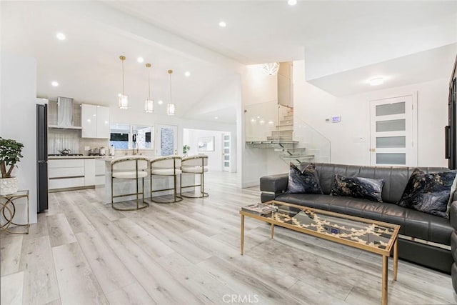 23500 Lloyd Houghton Pl, Newhall, CA 91321 - living area featuring lofted ceiling, light wood-style flooring, stairs, and recessed lighting