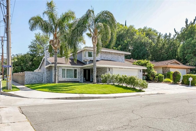 23500 Lloyd Houghton Pl, Newhall, CA 91321 - view of front of home with stone siding, driveway, a garage, and a chimney