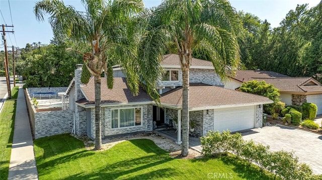 23500 Lloyd Houghton Pl, Newhall, CA 91321 - view of front of home with an attached garage, stone siding, driveway, a front lawn, and a shingled roof