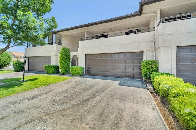 204 Hawk Ln, Palmdale, CA 93551 - view of front of property featuring stucco siding, driveway, a balcony, and a garage
