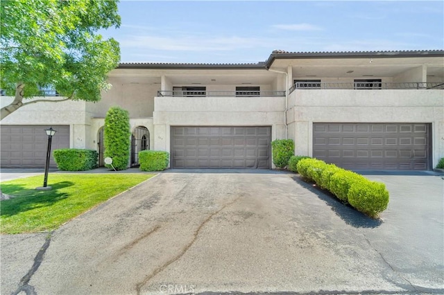 204 Hawk Ln, Palmdale, CA 93551 - view of property with asphalt driveway, stucco siding, a garage, and a balcony