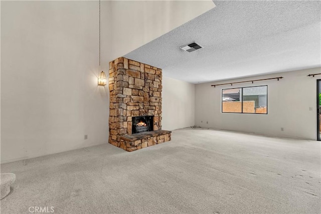 204 Hawk Ln, Palmdale, CA 93551 - unfurnished living room featuring a textured ceiling, carpet flooring, and a stone fireplace