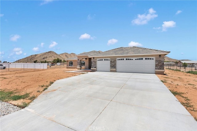20020 Symeron Rd, Apple Valley, CA 92307 - view of front facade with an attached garage, stone siding, driveway, and a mountain view