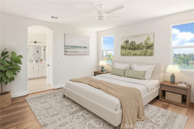 967 Strawberry Creek St, Chula Vista, CA 91913 - bedroom with arched walkways, multiple windows, light wood-style flooring, and connected bathroom