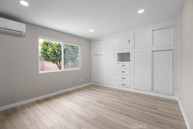 5021 Harbor St, Commerce, CA 90040 - unfurnished bedroom featuring an AC wall unit, light wood-style flooring, recessed lighting, and multiple closets