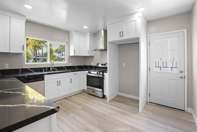 5021 Harbor St, Commerce, CA 90040 - kitchen with wall chimney range hood, appliances with stainless steel finishes, white cabinets, light wood-style floors, and recessed lighting
