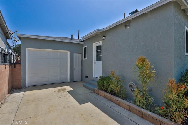 5021 Harbor St, Commerce, CA 90040 - view of front facade with driveway, an attached garage, and stucco siding