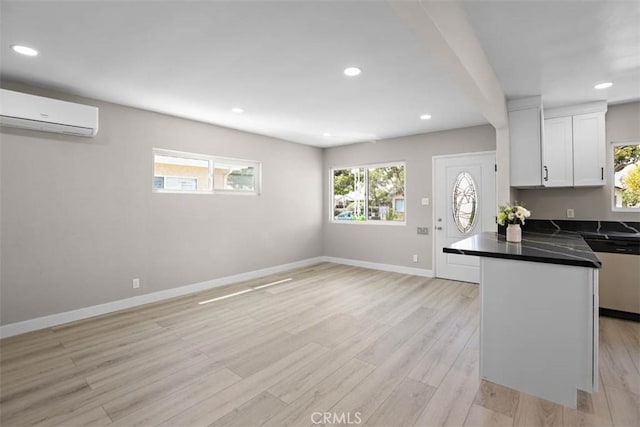 5021 Harbor St, Commerce, CA 90040 - kitchen with stainless steel dishwasher, a wall unit AC, dark countertops, healthy amount of natural light, and recessed lighting