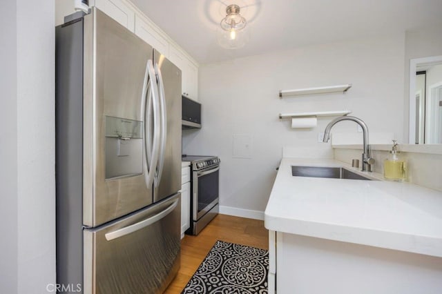 5585 E Pacific Coast Unit 141, Long Beach, CA 90804 - kitchen with stainless steel appliances, open shelves, white cabinetry, light wood-type flooring, and light countertops