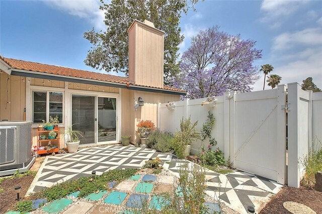 1068 Border Ave, Corona, CA 92882 - rear view of property with a chimney, a gate, a patio area, and a tiled roof