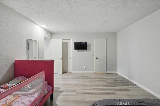 1657 E Kingsley Ave Unit B, Pomona, CA 91767 - bedroom with a textured ceiling and wood finished floors