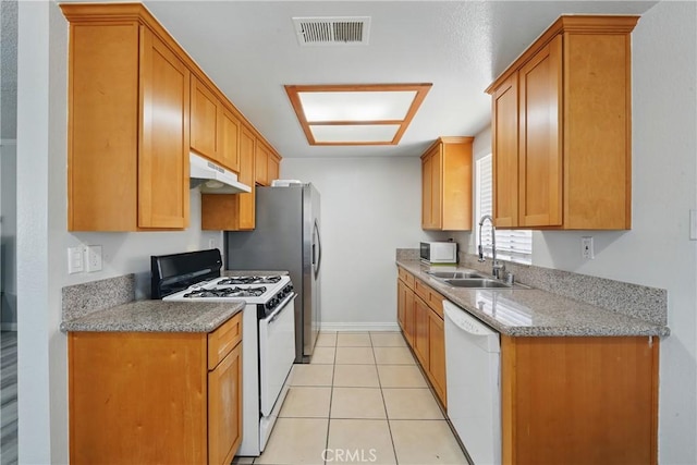 1657 E Kingsley Ave Unit B, Pomona, CA 91767 - kitchen with white appliances, under cabinet range hood, light stone countertops, light tile patterned floors, and brown cabinets