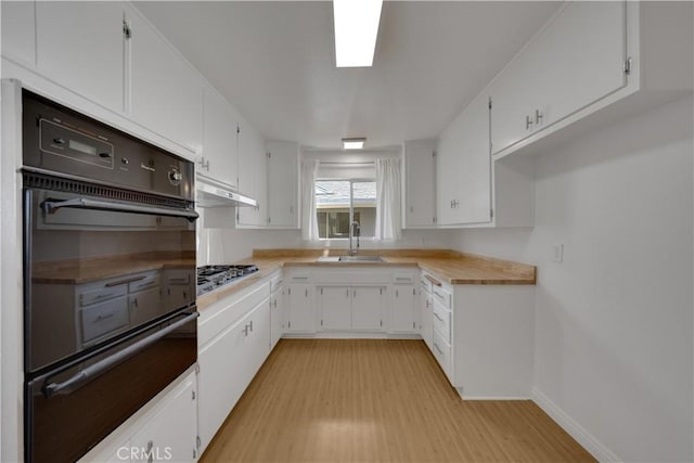 8341 Sierra Bonita Ave, Rosemead, CA 91770 - kitchen featuring oven, a warming drawer, under cabinet range hood, stainless steel gas stovetop, and light wood finished floors