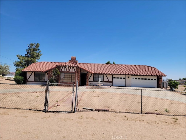 15440 Cactus St, Hesperia, CA 92345 - view of front of house featuring a tile roof, an attached garage, a gate, driveway, and a chimney