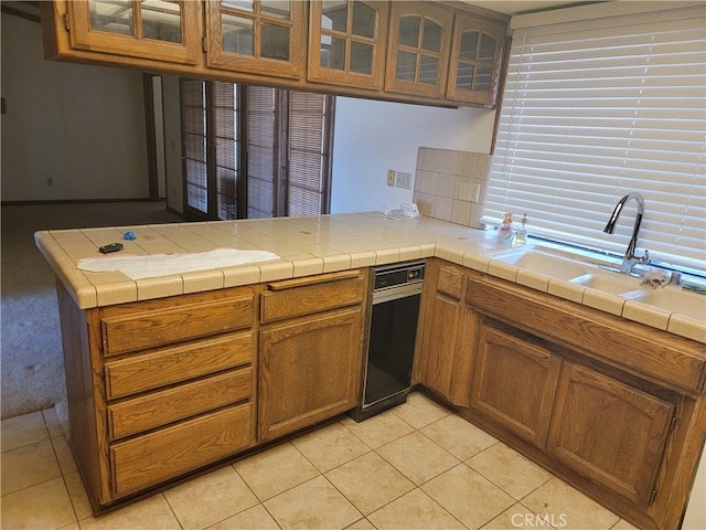 15440 Cactus St, Hesperia, CA 92345 - kitchen with light tile patterned floors, brown cabinets, glass insert cabinets, and a peninsula