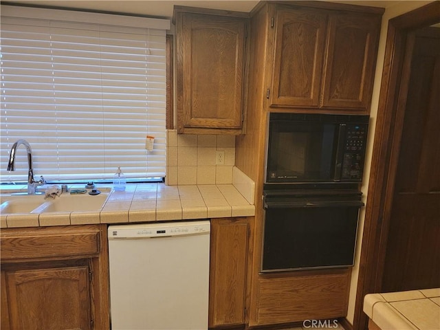 15440 Cactus St, Hesperia, CA 92345 - kitchen featuring black appliances, tile countertops, decorative backsplash, and brown cabinets