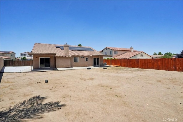 12671 Shorewood Ln, Victorville, CA 92392 - back of house with a patio, solar panels, a chimney, a fenced backyard, and a tile roof