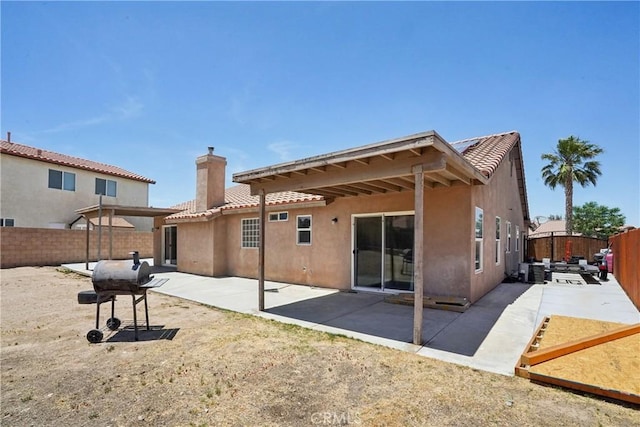 12671 Shorewood Ln, Victorville, CA 92392 - back of house featuring a chimney, stucco siding, a fenced backyard, and a tiled roof