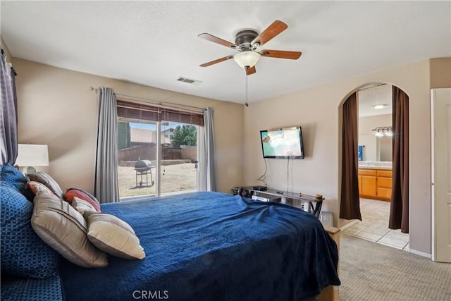 12671 Shorewood Ln, Victorville, CA 92392 - bedroom with arched walkways, access to exterior, light colored carpet, a ceiling fan, and connected bathroom