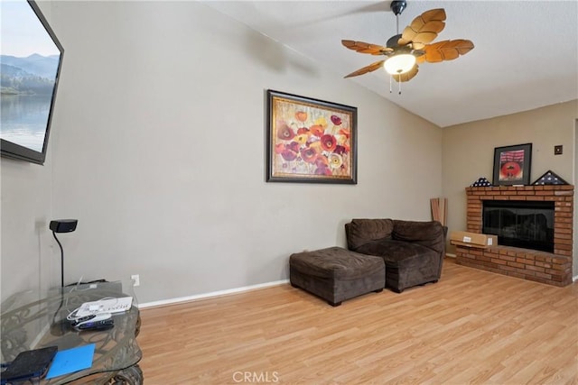 12671 Shorewood Ln, Victorville, CA 92392 - sitting room with vaulted ceiling, wood finished floors, a brick fireplace, and ceiling fan