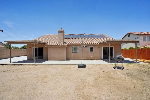 12671 Shorewood Ln, Victorville, CA 92392 - back of house featuring stucco siding, a tile roof, a chimney, a fenced backyard, and a patio area