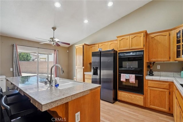 12671 Shorewood Ln, Victorville, CA 92392 - kitchen featuring stainless steel fridge, lofted ceiling, light wood-type flooring, a kitchen bar, and ceiling fan