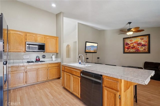12671 Shorewood Ln, Victorville, CA 92392 - kitchen with stainless steel appliances, light wood-type flooring, ceiling fan, open floor plan, and a center island with sink