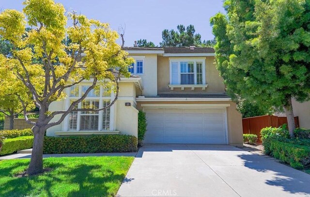 15 Parisville, Aliso Viejo, CA 92656 - view of front facade featuring stucco siding, an attached garage, and driveway