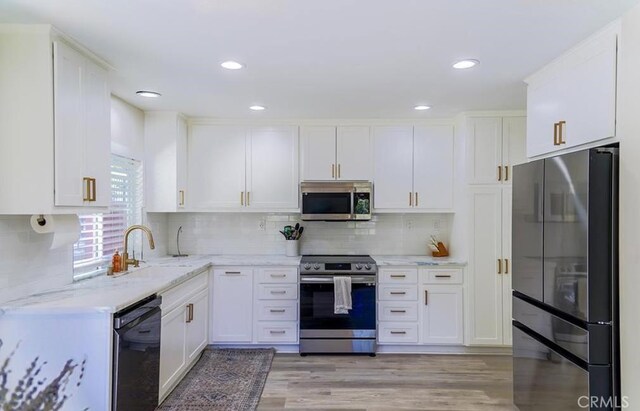 15 Parisville, Aliso Viejo, CA 92656 - kitchen featuring stainless steel appliances, white cabinets, light stone countertops, decorative backsplash, and light wood-style floors