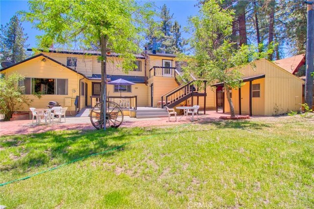 960 Snowbird Rd, Wrightwood, CA 92397 - back of property with a lawn, a patio area, an outbuilding, and stairs