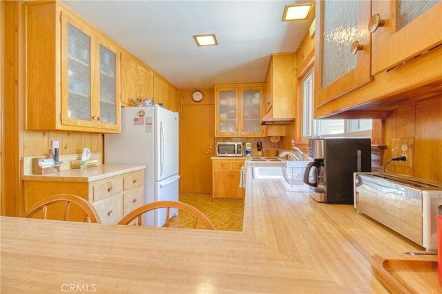 960 Snowbird Rd, Wrightwood, CA 92397 - kitchen with stainless steel microwave, freestanding refrigerator, glass insert cabinets, and light countertops