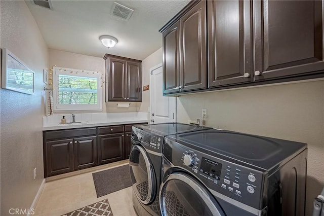3486 Cascade Creek Ave, Merced, CA 95340 - laundry area with cabinet space, washer and clothes dryer, and a textured wall