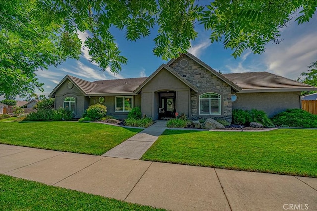 3486 Cascade Creek Ave, Merced, CA 95340 - ranch-style house with a front lawn, stucco siding, and stone siding