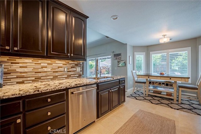 3486 Cascade Creek Ave, Merced, CA 95340 - kitchen with dishwasher, backsplash, dark brown cabinets, light stone countertops, and recessed lighting