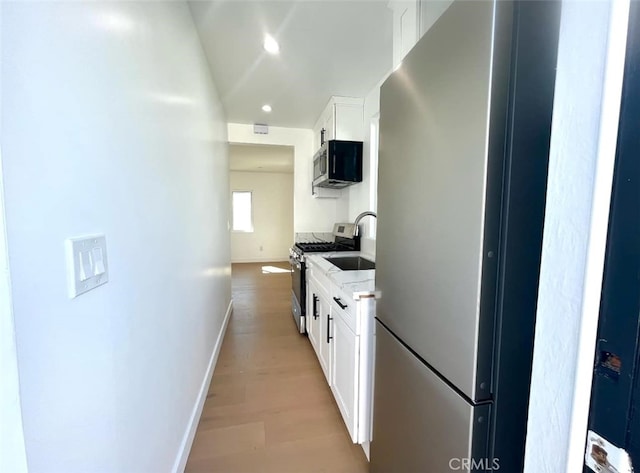624 W 38th St, San Pedro, CA 90731 - kitchen featuring stainless steel appliances, white cabinets, light stone counters, light wood-style flooring, and recessed lighting
