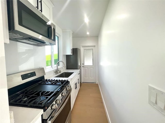 624 W 38th St, San Pedro, CA 90731 - kitchen with stainless steel appliances, white cabinets, light countertops, light wood-style floors, and recessed lighting
