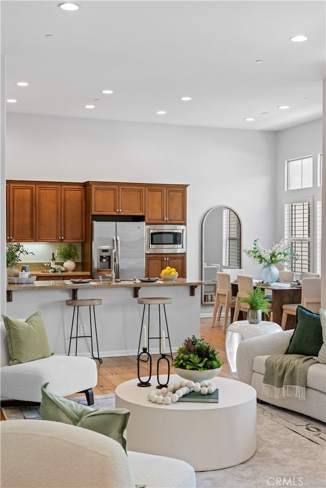 83 City Stroll, Irvine, CA 92620 - living room with light wood-style flooring, a towering ceiling, and recessed lighting