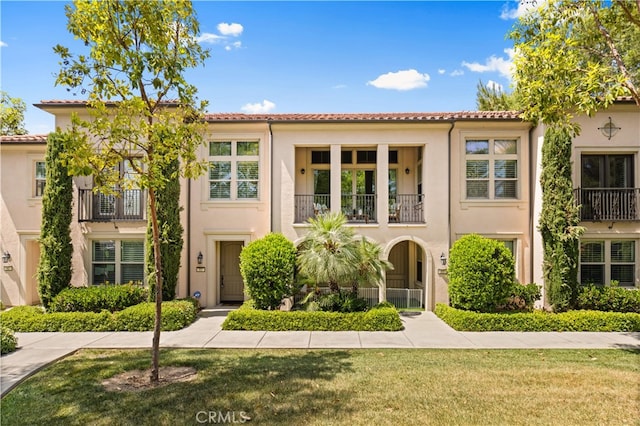 83 City Stroll, Irvine, CA 92620 - view of front of property with a balcony, stucco siding, a front lawn, and a tiled roof