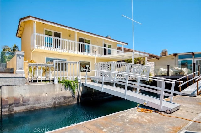 16781 Edgewater Ln, Huntington Beach, CA 92649 - rear view of property with a balcony, stucco siding, and a water view