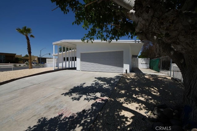 14163 Wimbleton Dr, Victorville, CA 92395 - view of front of property with concrete driveway, stucco siding, a carport, and an attached garage